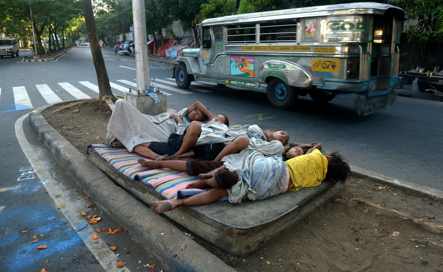Street children sleep on a discarded mattress on a center island near a road crossing in Manila, Philippines, in April. After 15 years of the Millennium Development Goals, Asia as a region has had the fastest progress, reports the U.N., yet hundreds of millions of people there remain in extreme poverty.